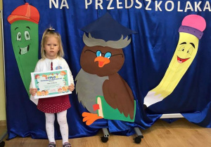 Nikola wraz ze swoim dyplomem przedszkolaka.